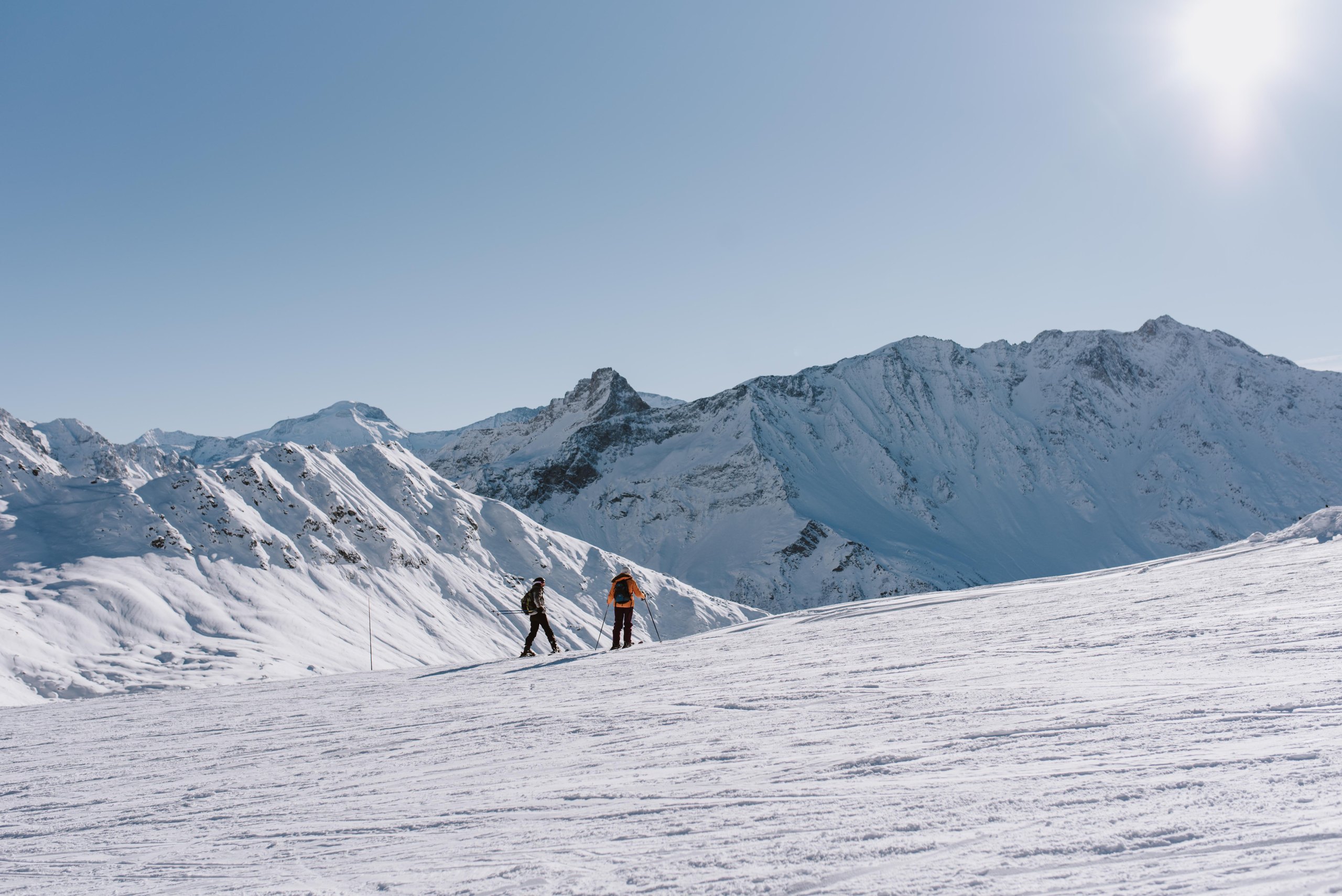 Dwie osoby jadą na nartach po stoku w Les Arcs