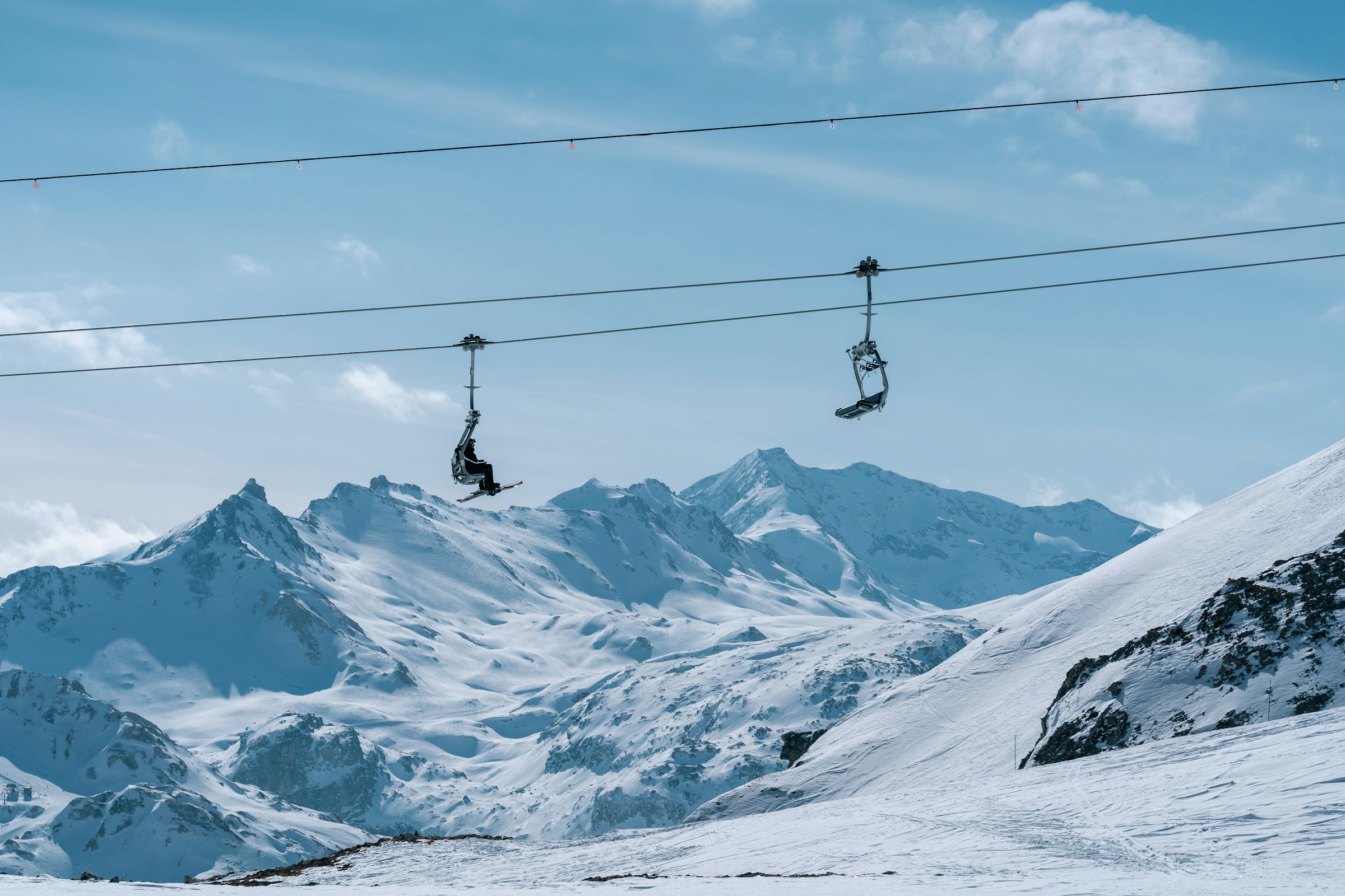 Wyciąg krzesełkowy Marais nad zaśnieżonymi szczytami, ujęcie ze stoku Silène w obszarze Tignes – Val d'Isère